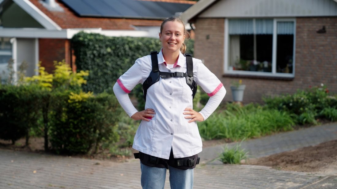 Frau trägt Darwingback exoskelett bei der arbeit in der altenpflege